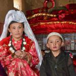 Kyrgyz woman and son in their yurt. Married women wear white head coverings, single women wear red. 