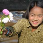 Girl selling flowers at the floating market.