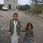 Kids with their home in the background.